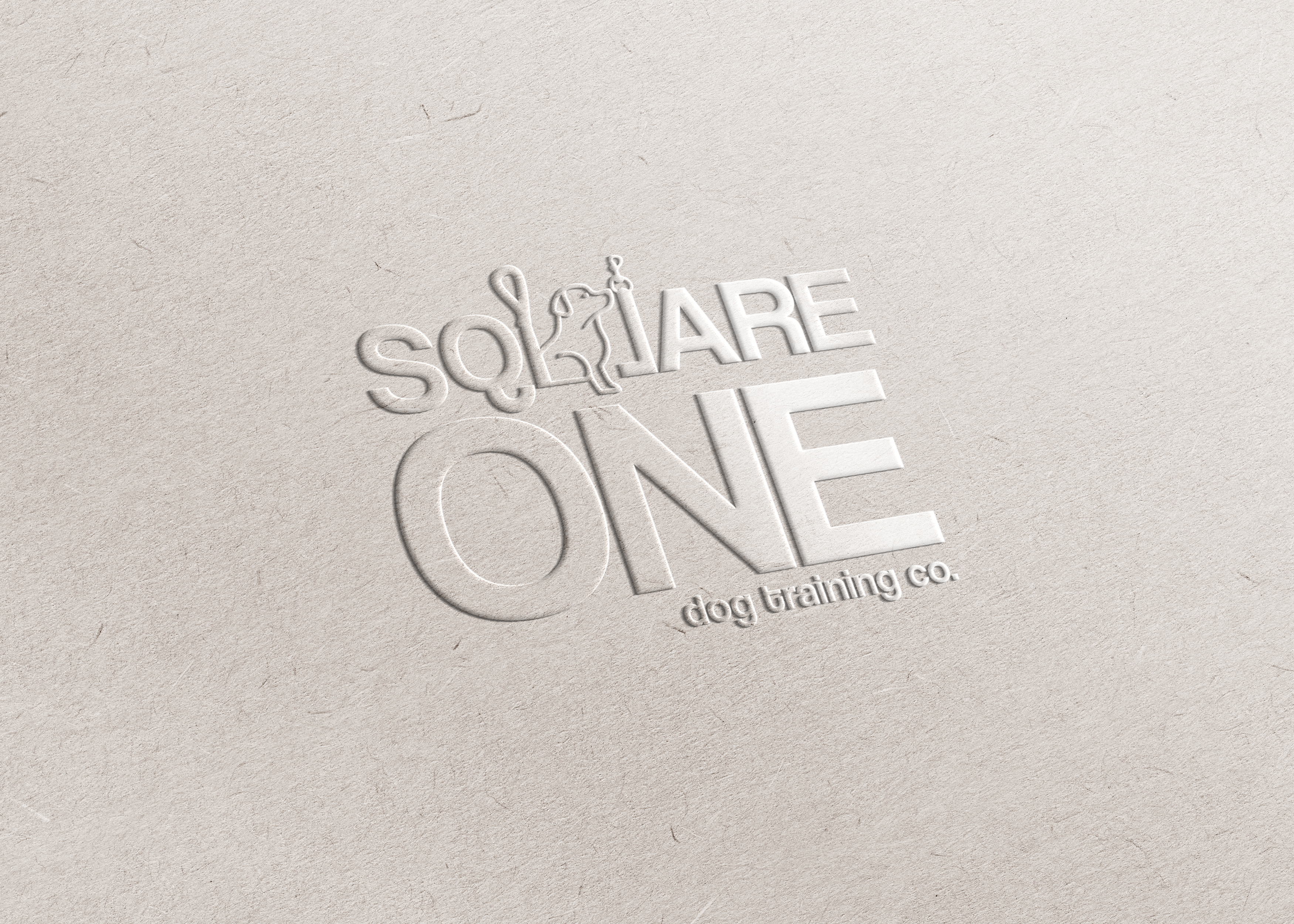 Embossed Square One dog training co. logo on white paper